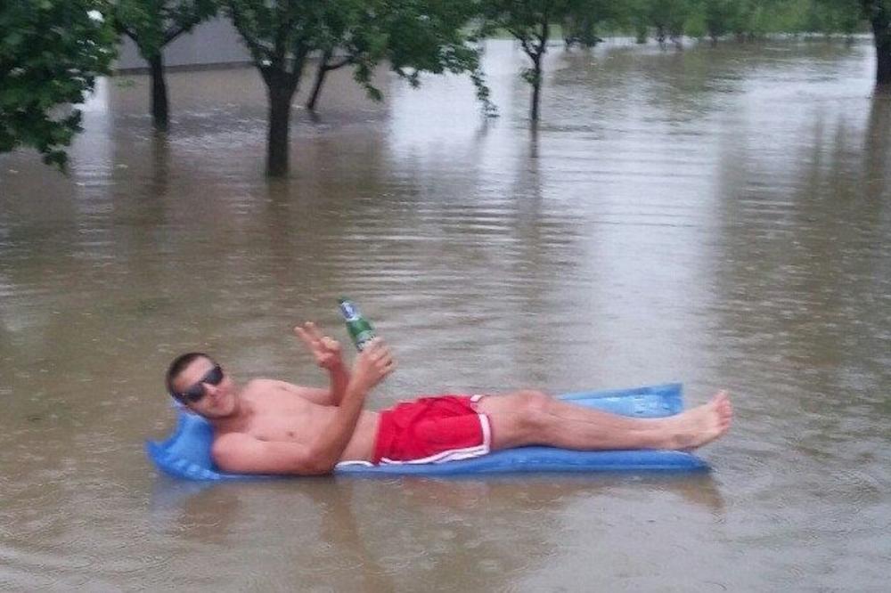 Uživa čovek usred katastrofe: Sve pod vodom a ovaj car plovi sa pivom u ruci (FOTO)