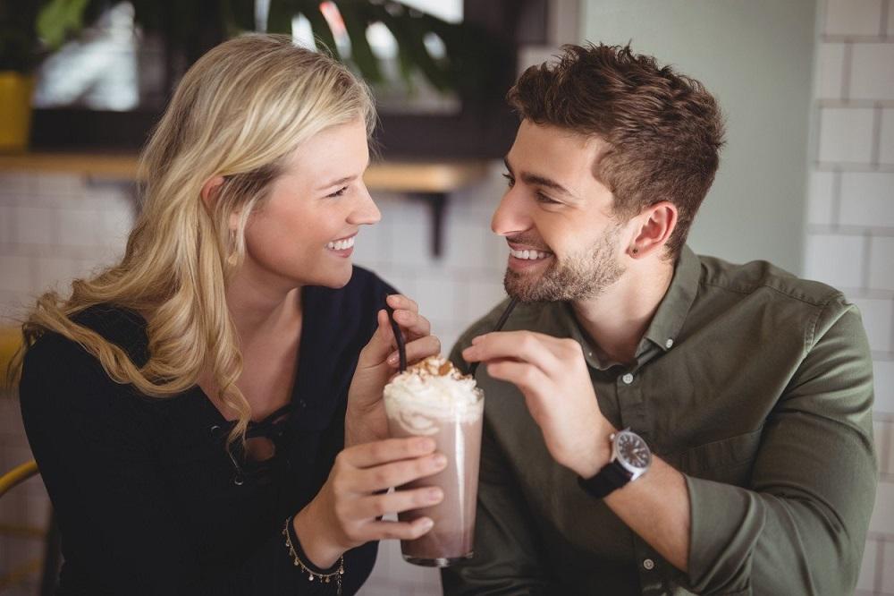 Devojka i dečko piju kafu