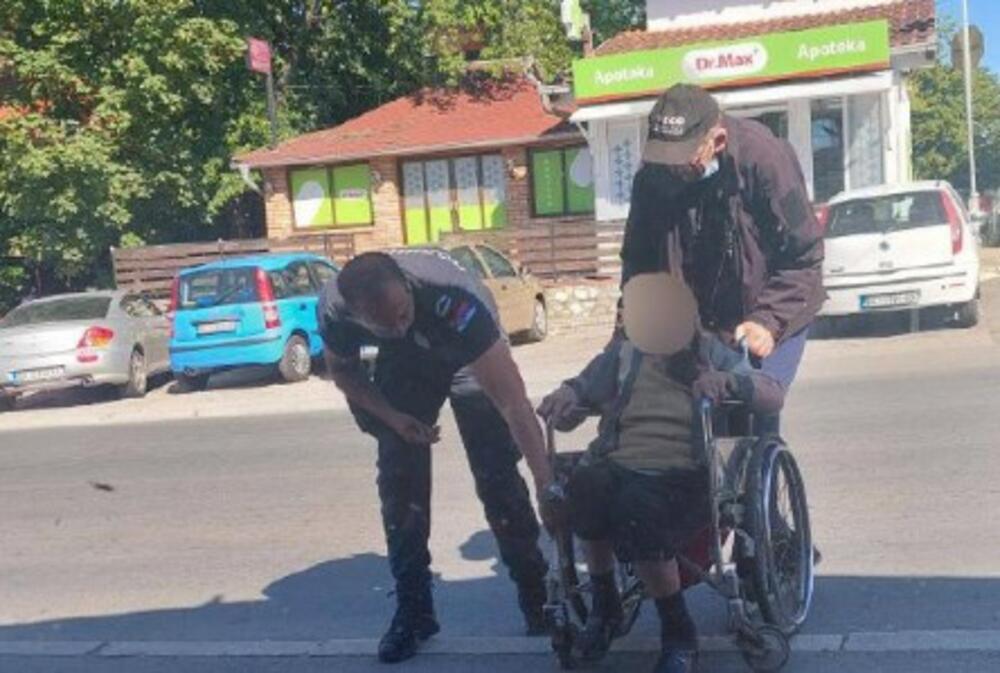 Policajac pomaže deki i baki da pređu ulicu